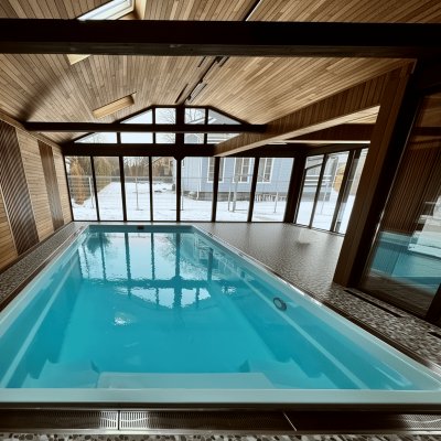 Крытый бассейн с панорамными окнами и деревянной отделкой интерьера
